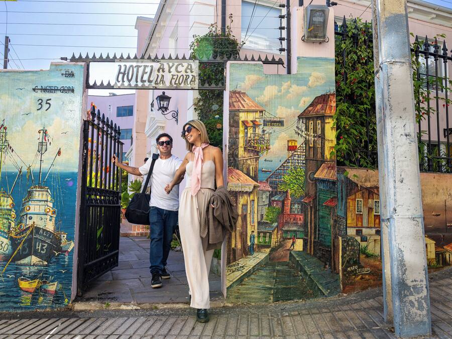 A hotel entrance with a colorful mural of boats and buildings.