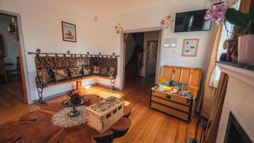 A cozy living room with a wooden bench, a small table with a box, and a fireplace.
