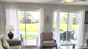Uma sala de estar ampla com sofá, poltrona e mesa de jantar.