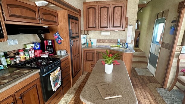 Una cocina con gabinetes de madera, una isla central y una estufa.