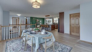 A dining area with a round table, chairs, and a rug.
