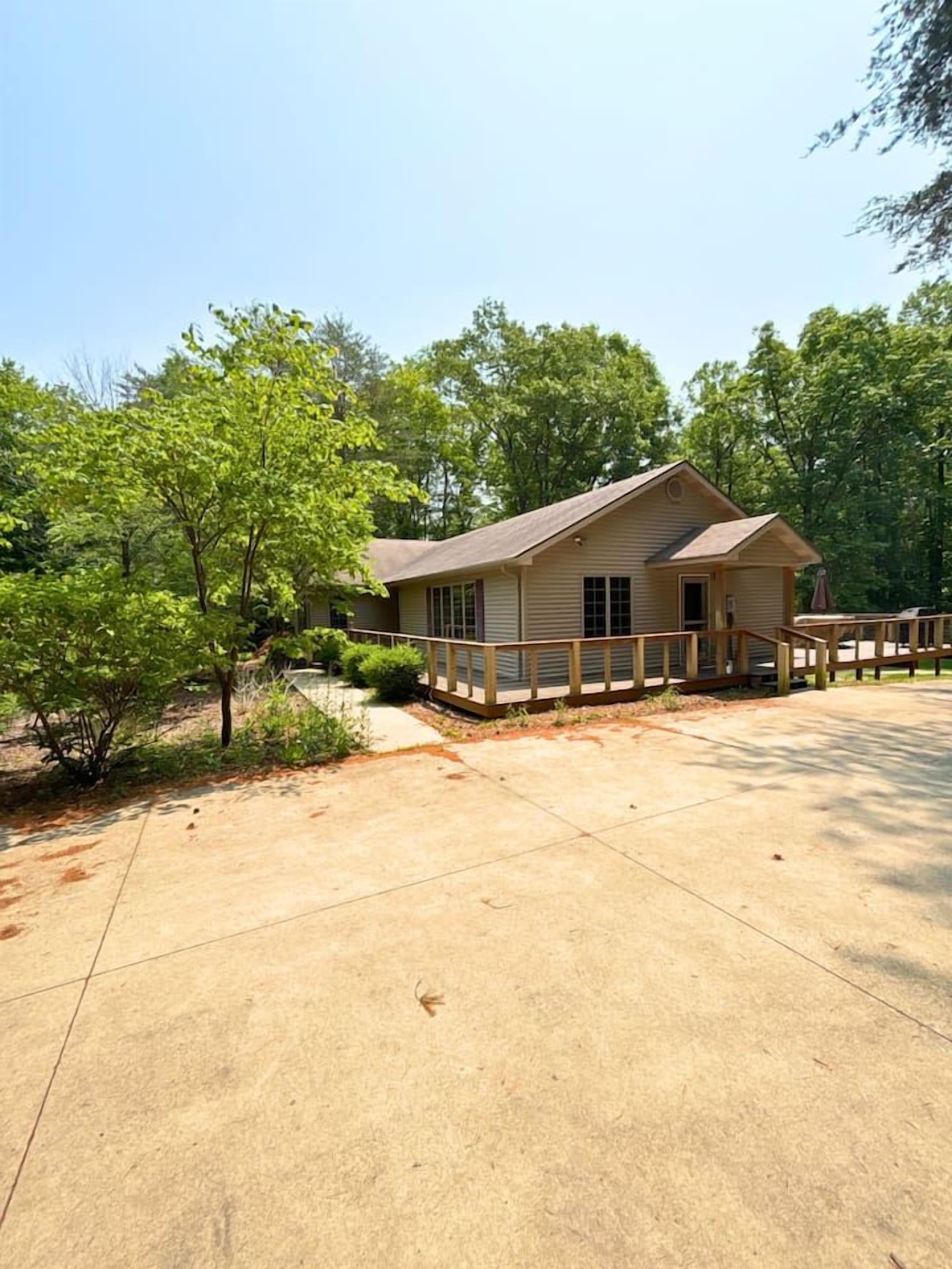 A small, single-story cabin with a wooden deck and a covered picnic table.