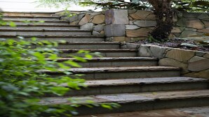 A set of stone steps leading up to a stone wall.