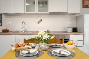 Une table à manger élégamment dressée, avec des assiettes, des couverts et un vase de fleurs.