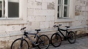 A building with two arched windows and a row of bicycles parked against the wall. - Studio apartment Eva- Old City Center (Zadar)
