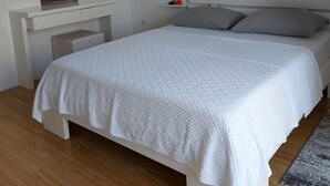A bedroom with a bed, a desk, and a wardrobe.
