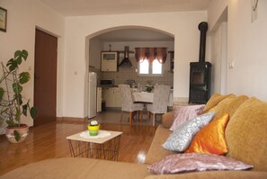 Relax in this open-plan living space with a sofa, dining table, and fully equipped kitchen.