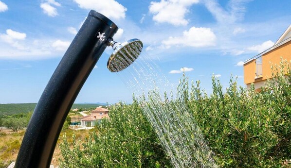 A showerhead with water spraying over a garden. - Four bedroom villa with private pool (Sukosan)