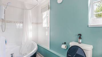 Un baño con bañera, inodoro y ducha.