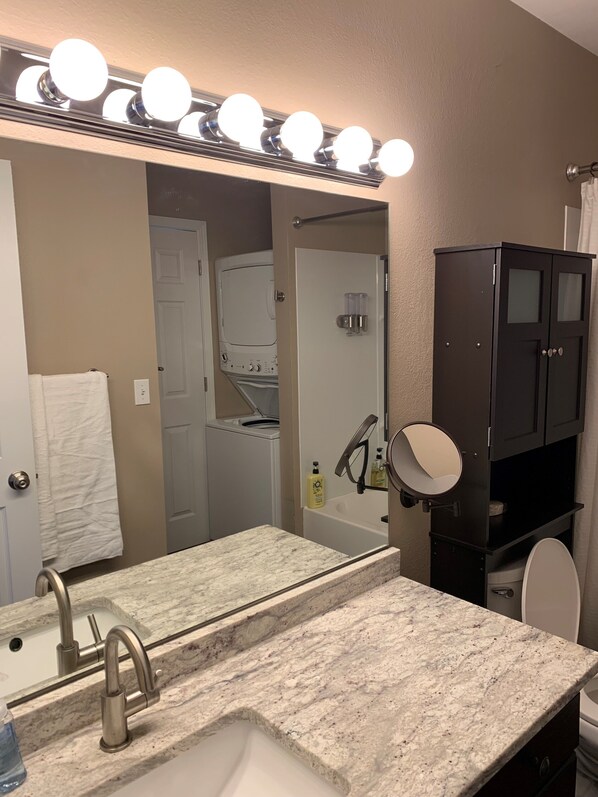 A bathroom with a sink, mirror, and lights above the mirror. - Anchorage Guest Stay #4 (Anchorage)
