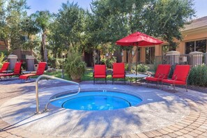 A pool area with red chairs and a red umbrella. - Vacation Worthy and great Location (Mesa)