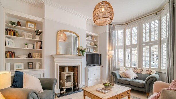 A living room with a fireplace, sofas, a coffee table, and a bookshelf.