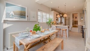 A modern kitchen with wooden countertops, a central island, and pendant lighting.