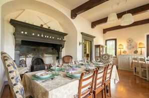 A dining room with a fireplace, wooden beams, and a table set for six. - Splendid Chianti Tuscany Villa with Panoramic Pool ,Cypress Trees-Lined Drive (Montespertoli)