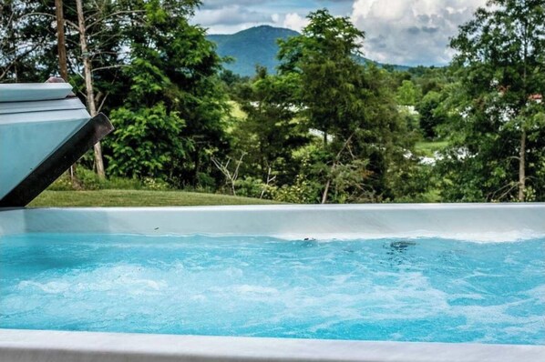 Relax by the serene pool surrounded by lush greenery and majestic mountains.