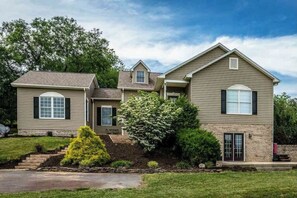 Stunning two-story home with a symmetrical facade, featuring a gabled roof and charming shutters.