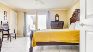 A bedroom with a bed, a chair, a dresser, and a ceiling fan. - Halifax Riverfront Oasis - 8 Bedrooms with pool (Daytona Beach)