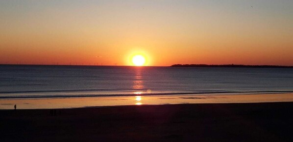 A sunset over a calm sea with a distant shoreline. - - VILLA FARINETTE - (Vias)