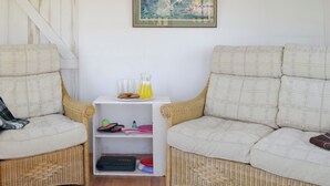 A room with two wicker sofas, a white shelf with items, and a framed picture on the wall. - 3 bedroom accommodation in Blakeney Hill, near Lydney, Forest of Dean (Blakeney Hill, near Lydney, Forest of Dean)