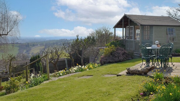 A cottage with a garden, a wooden deck, and a view of the countryside. - 3 bedroom accommodation in Blakeney Hill, near Lydney, Forest of Dean (Blakeney Hill, near Lydney, Forest of Dean)