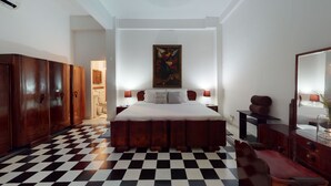 A bedroom with a checkered floor, a large bed, wooden wardrobe, and a painting on the wall. - -APARTMENT CIUDAD VIEJA-PLAZA BOLIVAR THIRD FLOOR- (Cartagena de Indias)