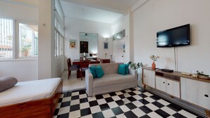 A modern living room with a checkered floor, a sofa with teal cushions, a TV mounted on the wall, and a dining area in the background. - -APARTMENT CIUDAD VIEJA-PLAZA BOLIVAR THIRD FLOOR- (Cartagena de Indias)