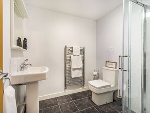 Une salle de bain avec un lavabo, des toilettes et une douche.