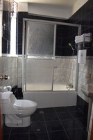 A bathroom with a glass-enclosed shower, a white toilet, and a sink.