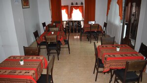 Comedor con varias mesas y sillas dispuestas en forma de U alrededor de un espacio de estar central.