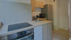 A compact kitchen with a built-in stove, oven, and a coffee maker.
