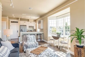 Relax in a spacious living area with a modern kitchen, comfortable seating, and a dining table.