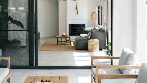 Een moderne woonkamer met een houten salontafel, twee banken en een open haard.