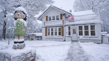 A two-story building with a balcony, a flag, and a snow-covered environment.