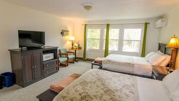 Une chambre d’hôtel avec deux lits, une télévision, un bureau et une chaise.