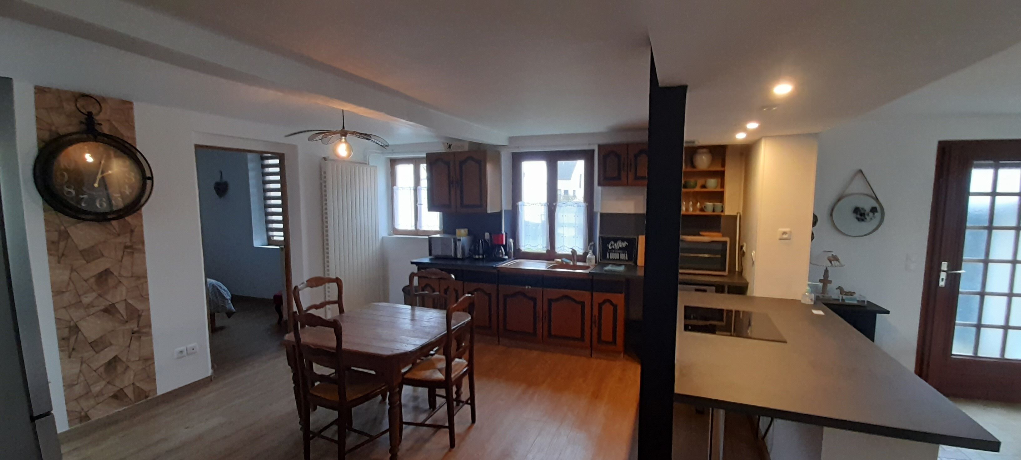 Una cucina moderna con mobili in legno, un tavolo da pranzo e un forno a incasso.