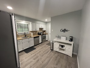 Enjoy cooking in this well-equipped kitchen with a coffee station, sink, stove, and dishwasher.