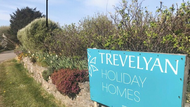 Placa de Trevelyan Holiday Homes com endereço de site.