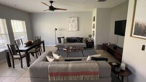 Una sala de estar moderna con un sofá, una mesa de centro y un comedor.