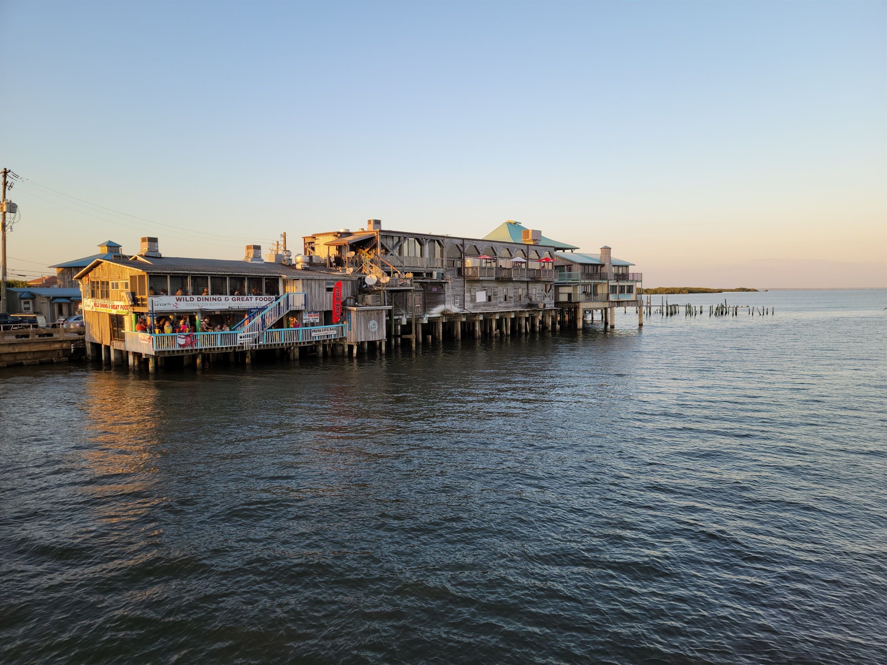 A waterfront building with multiple decks and a restaurant named "Wild Dining & Great Food".