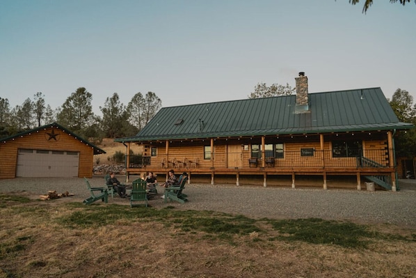 A wooden cabin with a covered porch and a stone chimney.