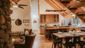 Una cocina amplia con armarios de madera, una isla central y un comedor con sillas y una mesa lista para una comida.