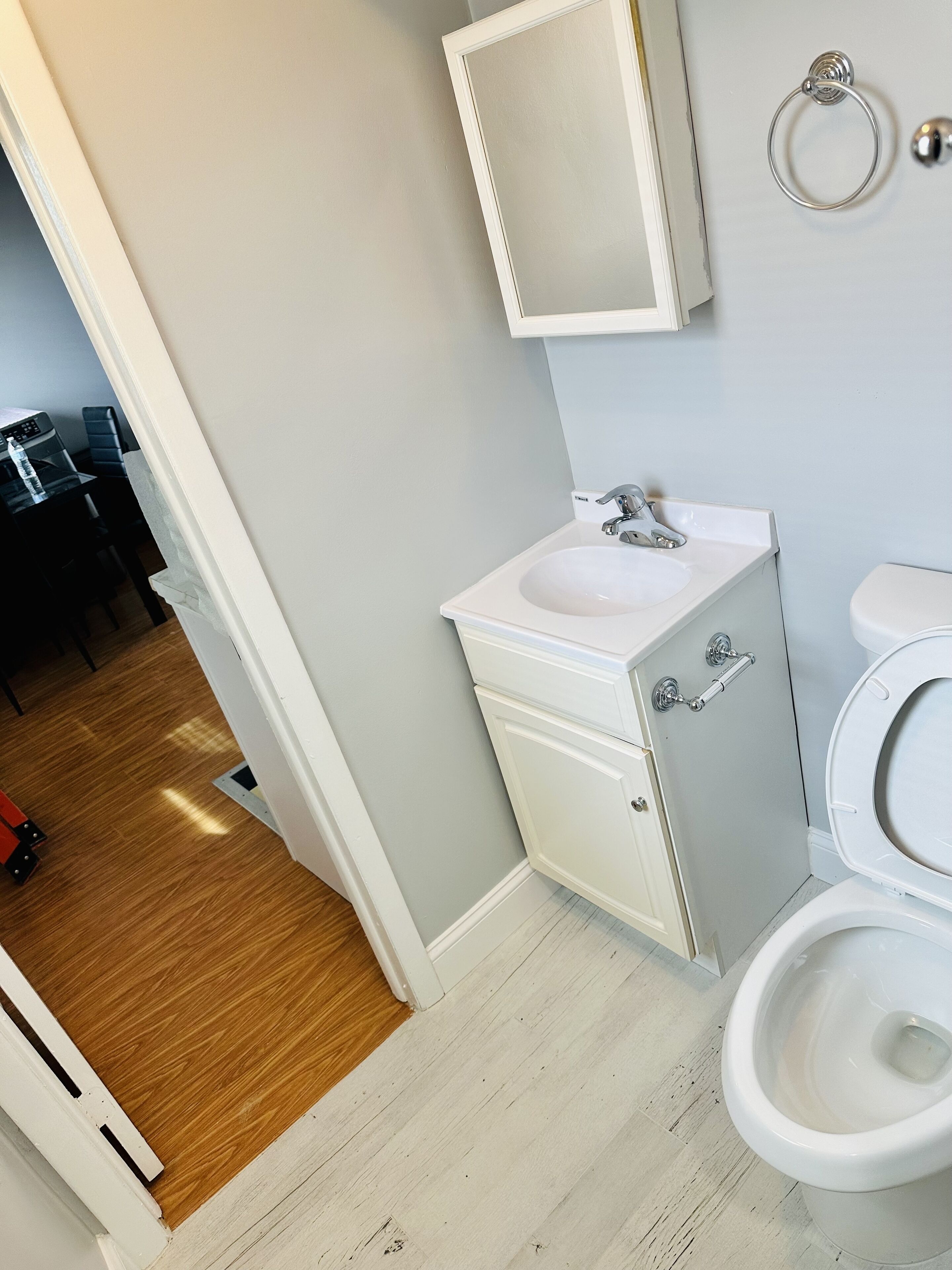 A bathroom with a white sink, a toilet, and a mirror.