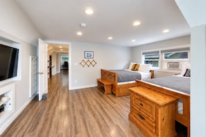 A bedroom with a wooden bed, a desk, and a television. - Lake Daze | Lakefront Powers Lake Home, Sleeps 11 (Genoa City)
