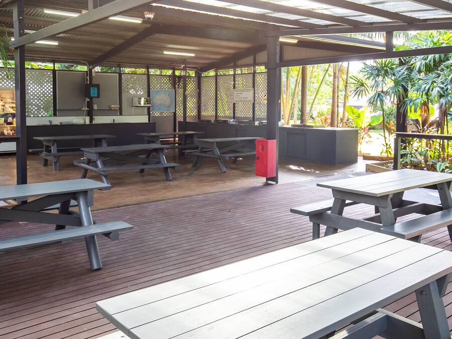 An outdoor covered patio area with picnic tables and a seating area.