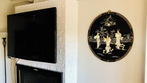 A living room with a fireplace, a mounted TV, and a decorative wall piece. - Comfortable studio just 3 minutes drive to downtown Moses Lake (Moses Lake)