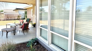 A covered patio with outdoor furniture, a wooden fence, and a view of a neighboring house. - Comfortable studio just 3 minutes drive to downtown Moses Lake (Moses Lake)