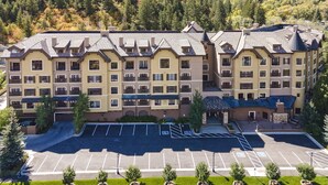 A multi-story hotel with a symmetrical facade, a central courtyard, and a parking lot.