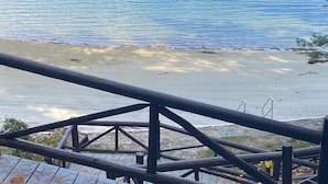 Una terraza de madera con vista a un cuerpo de agua tranquilo y un objeto flotando.