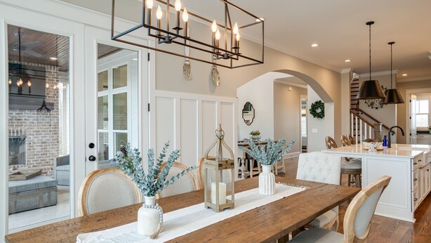 A spacious dining area with a wooden table, white chairs, and a modern chandelier. - Gated Private Estate With Pool, Hilltop Views, and Game Room on 8 acres (Thompson's Station)