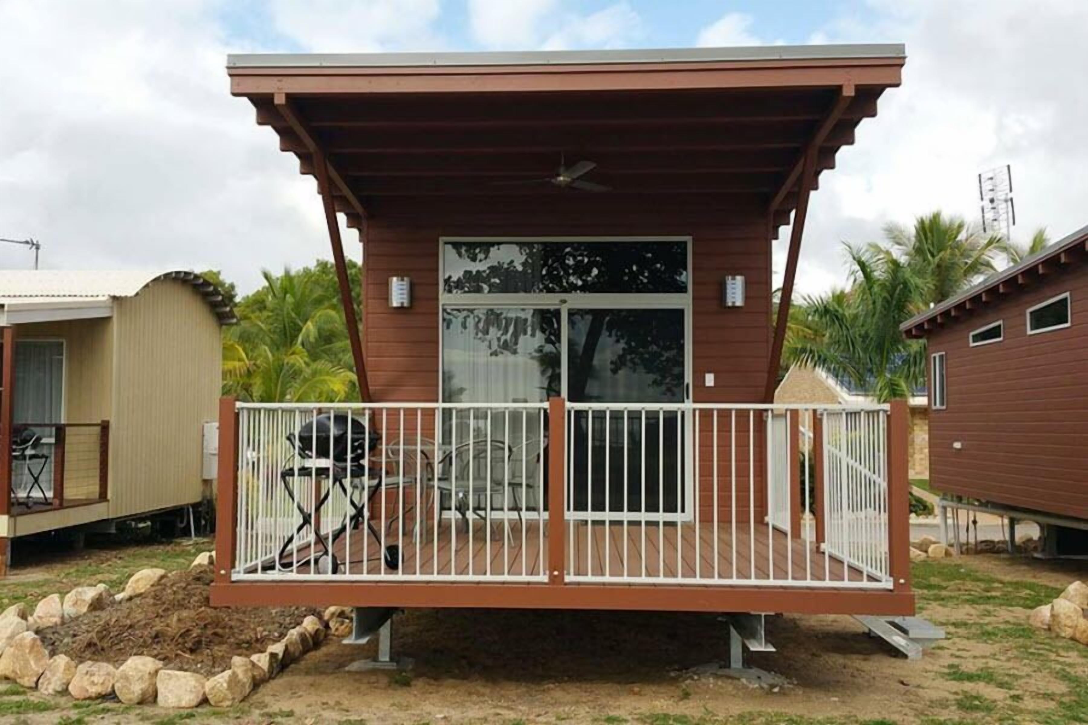Ein kleines, eingeschossiges Gebäude mit einer Veranda und einer Schiebetür.